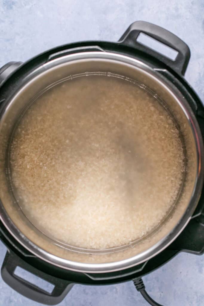 Uncooked rice in water in an Instant Pot.