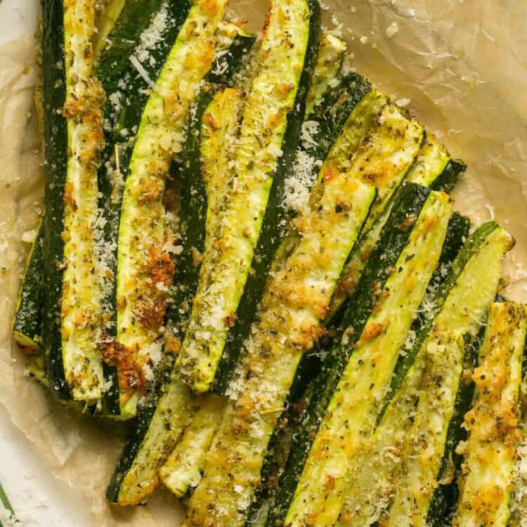 Roasted zucchini with parmesan on a platter.