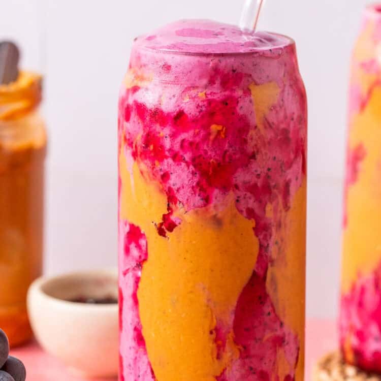 Peanut butter and jelly smoothie in a glass with a straw.