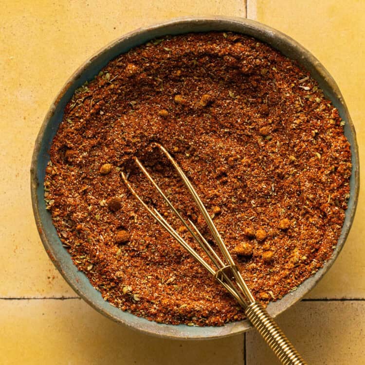 Chicken taco seasoning in a small bowl with a whisk.