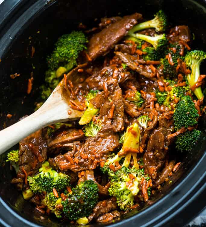 Crockpot Mongolian Beef and Brooccoli in a crock pot with a wooden spoon.