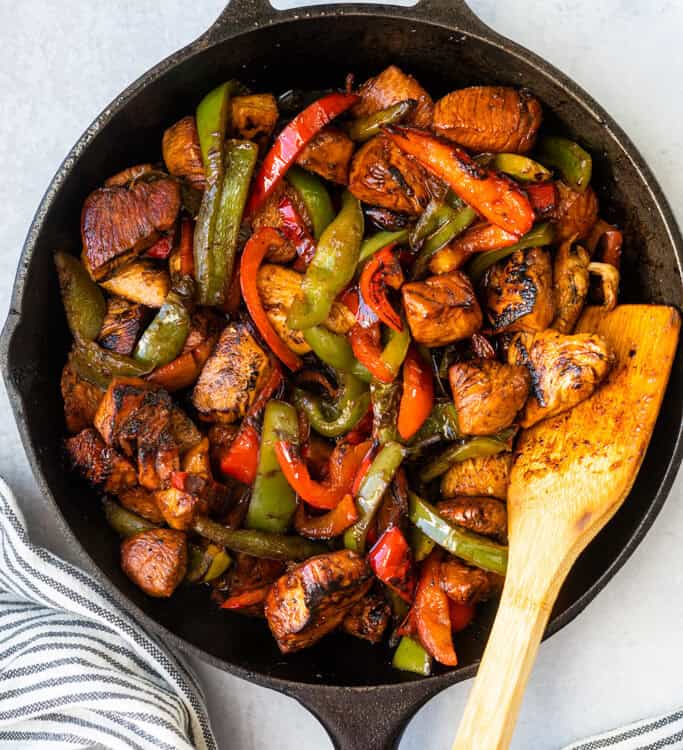 Honey Balsamic Chicken Pepper Skillet in skillet with a wooden spoon.