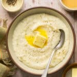 Quick grits topped with butter in a bowl with a spoon.