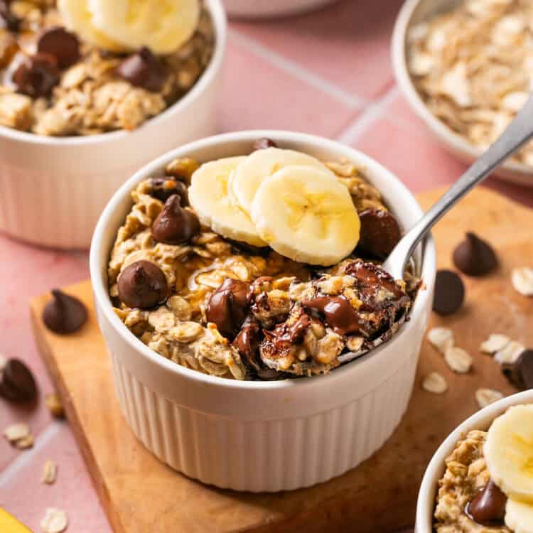 Single Serving Baked Oatmeal topped with sliced bananas in small bowls with spoons.