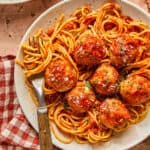 Healthy turkey meatballs served over spaghetti in a bowl with a fork.
