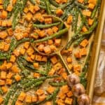 Roasted Sweet Potatoes and Green Beans on sheet pan with a serving spoon.