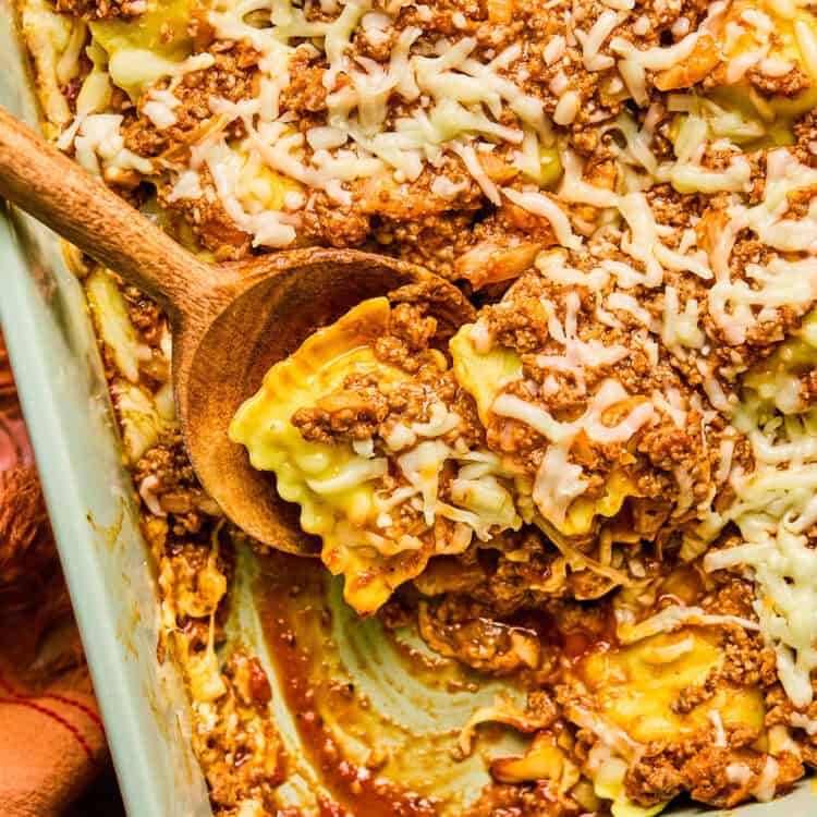 Baked Ravioli Casserole in a baking dish with a wooden spoon.