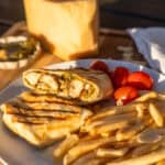 Pesto Grilled Chicken Wrap on a plate with fries.