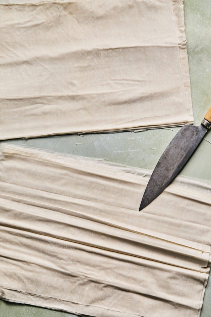 Phyllo pastry sheets with a knife.