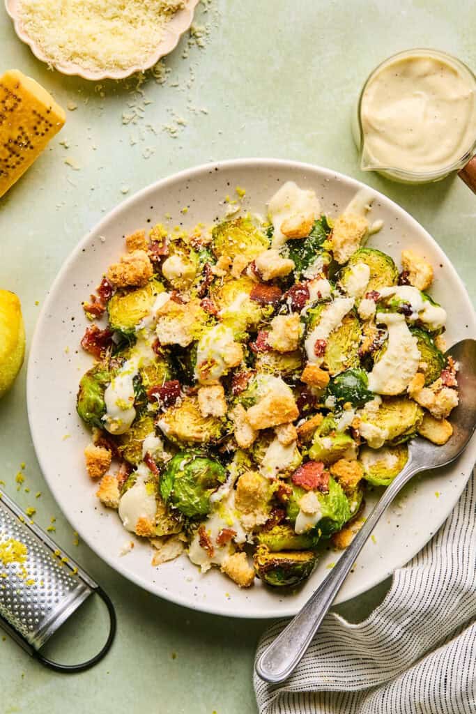 Caesar brussels sprouts on a plate with a fork.