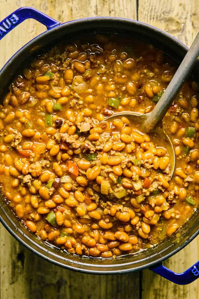 Cowboy Baked Beans in a pot with a ladle.