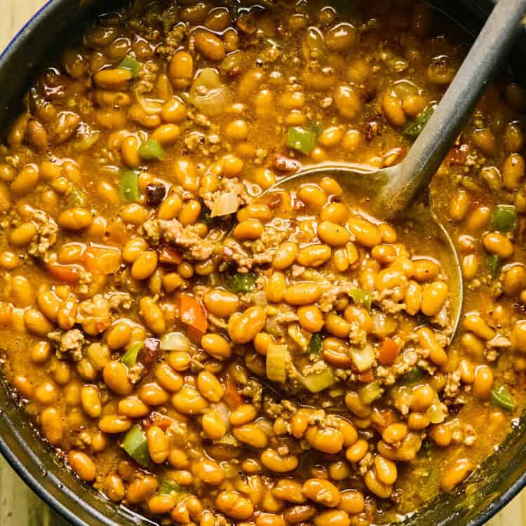 Cowboy Baked Beans in a pot with a ladle.
