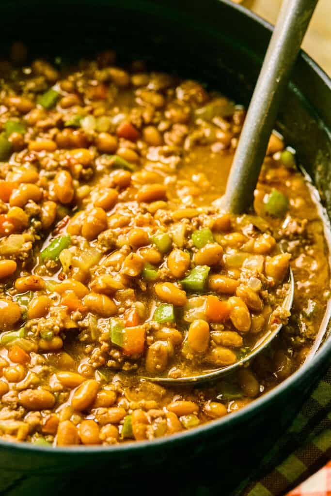 Cowboy Baked Beans in a pot with a ladle.