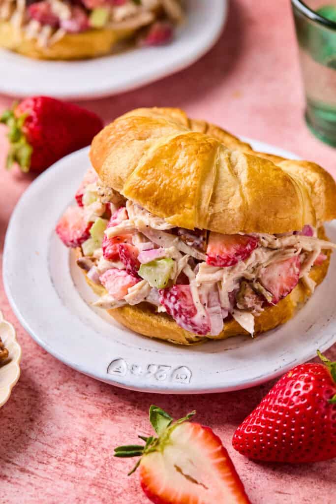 Strawberry Poppyseed Chicken Salad on a croissant on a small plate.