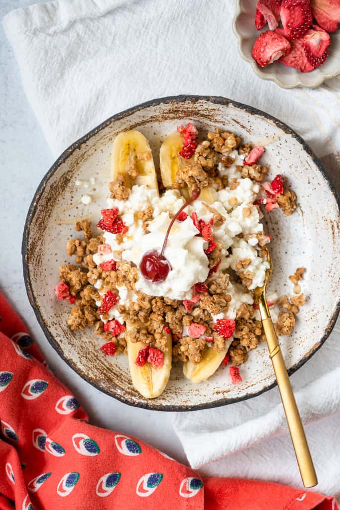Cottage Cheese Banana Split in a bowl with a spoon.