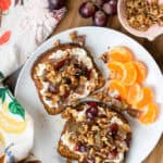 Grape and Walnut Cottage Cheese Toast with a side of clementines on a plate.
