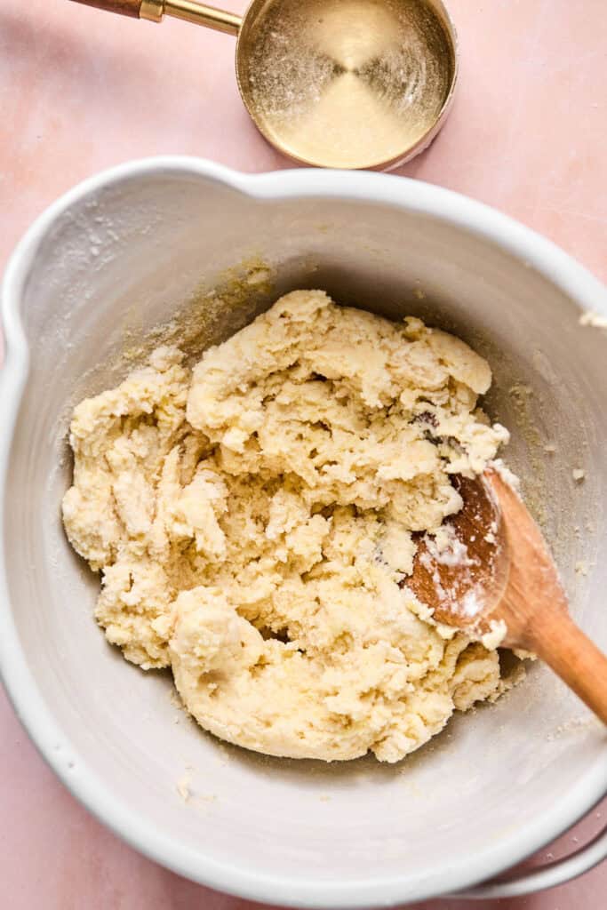 Pancake Mix Scones dough in a mixing bowl with a wooden spoon.