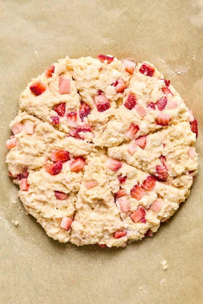 Pancake Mix Scones dough in a disc shape and sliced on parchment paper.