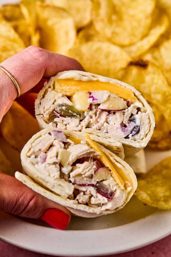 A hand holding Apple Grape and Walnut Chicken Salad Wraps.