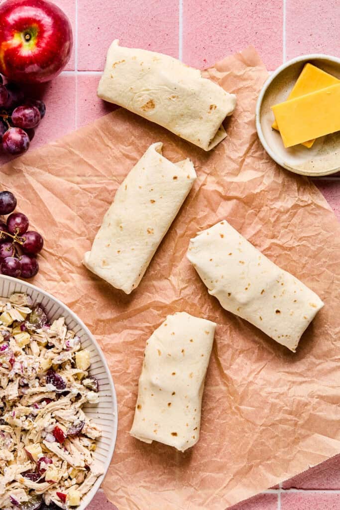 Apple Grape and Walnut Chicken Salad Wraps on parchment paper.