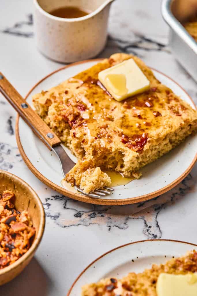 Maple Bacon Pancake Bake on a plate toped with butter and syrup.