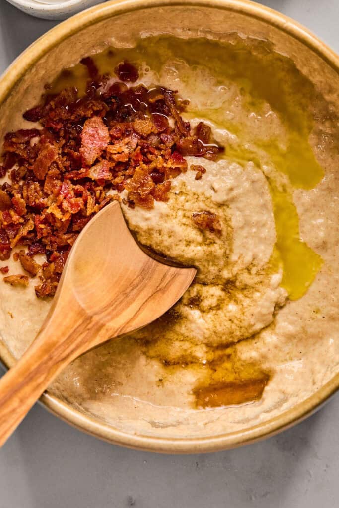 Chopped bacon and syrup being stirred into the Maple Bacon Pancake Bake batter.