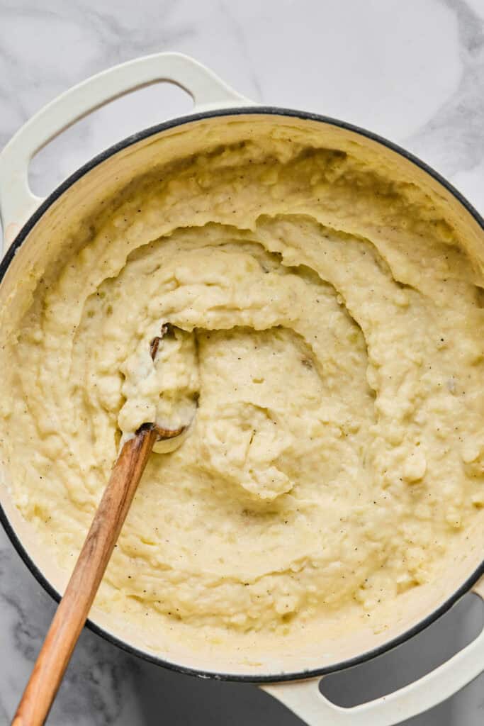 Garlic Mashed Potatoes in a pot with a wooden spoon.