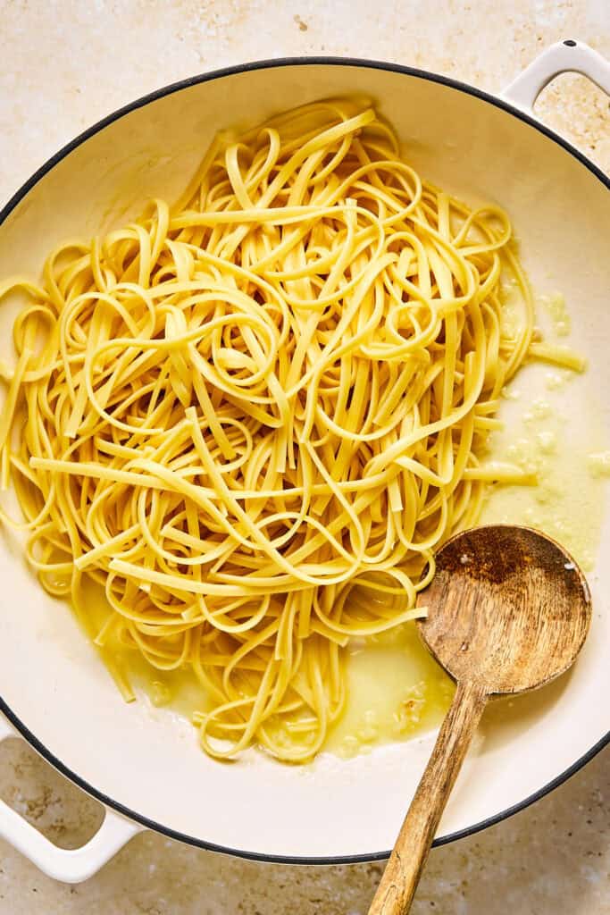 Noodles, butter, and garlic in a pot.