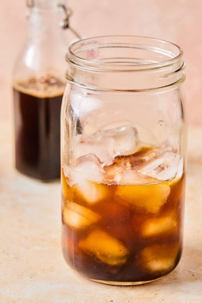 Glass jar with ice and espresso mixture.