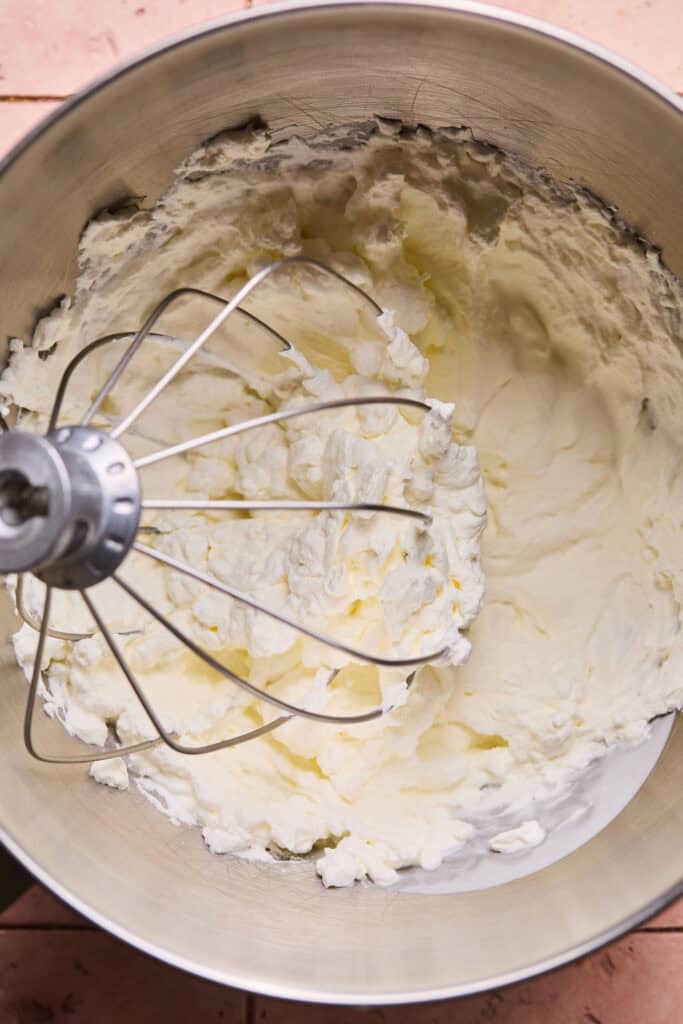 Heavy whipping cream being mixed in a mixer.