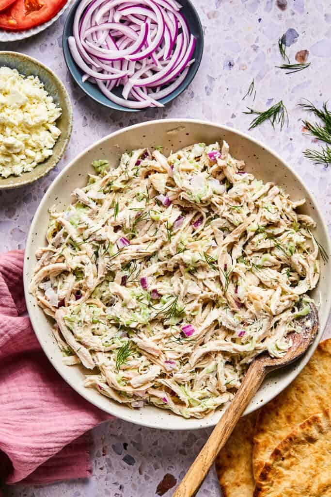 Tzatziki Chicken Salad i a bowl with a wooden spoon.