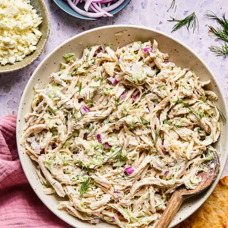 Tzatziki Chicken Salad i a bowl with a wooden spoon.