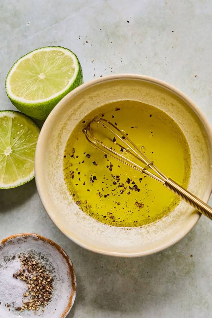Olive oil and lime juice in a small bowl with a whisk.