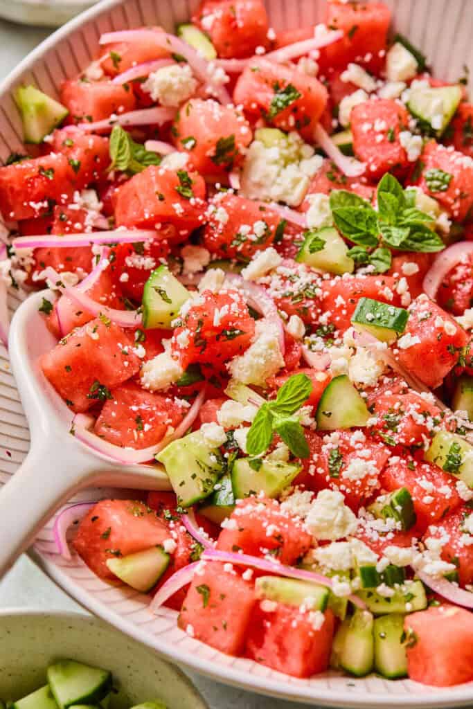 Watermelon Mint Salad in a large bowl with a wooden spoon.
