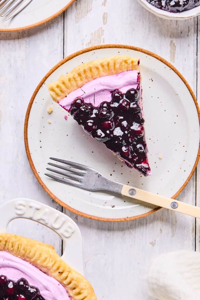 One slice of Wild Blueberry Greek Yogurt Pie on a small plate with a fork.