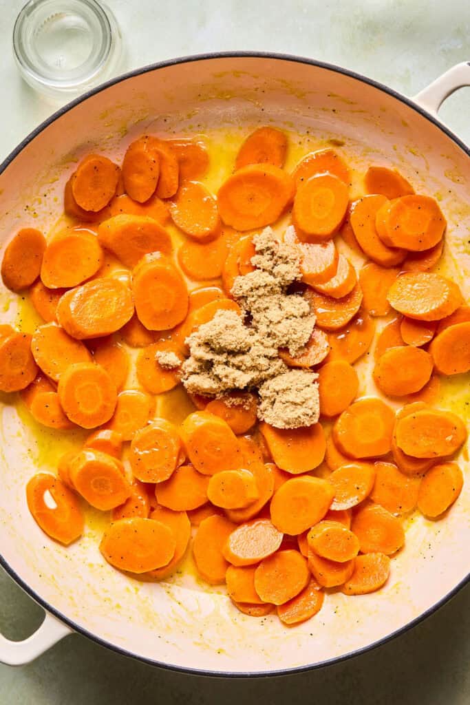 Brown sugar added to the sliced carrots in the skillet.