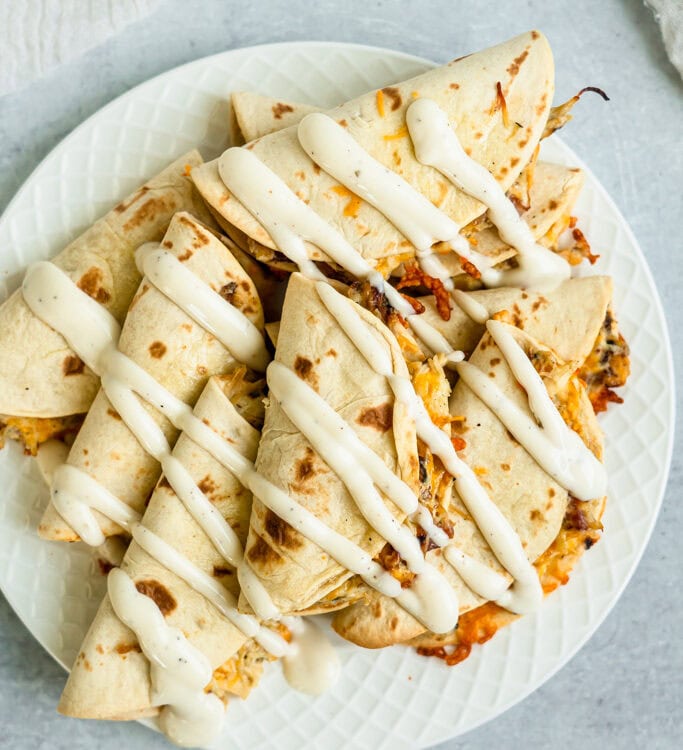 Chicken Bacon Ranch Tacos drizzled with sour cream on a plate.
