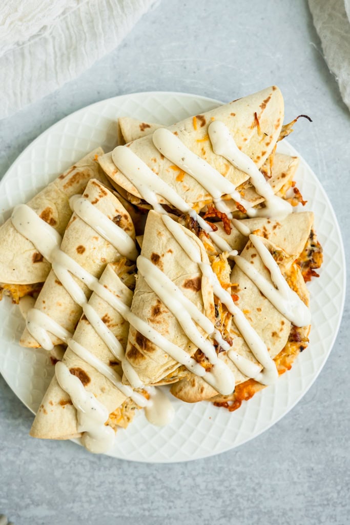Chicken Bacon Ranch Tacos drizzled with sour cream on a plate.