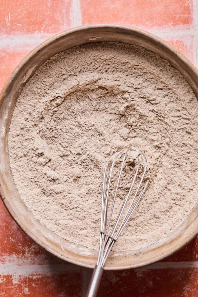 Dry ingrdients for Carrot cake bread in a bowl with whisk.