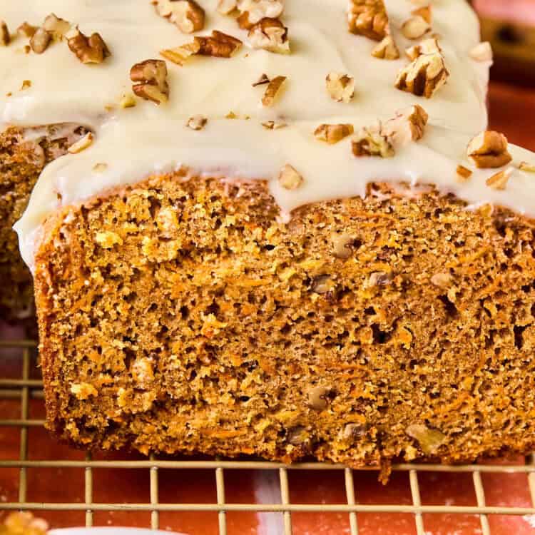 Carrot cake bread on a cooling rack with a knife.