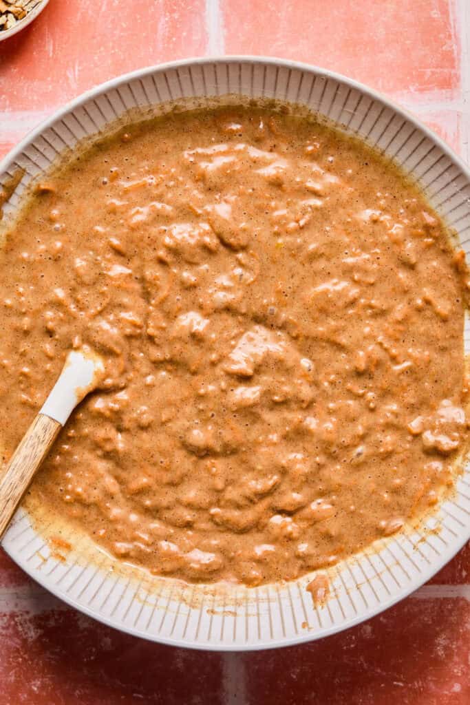 Carrot cake bread batter in a bowl with wooden spoon.