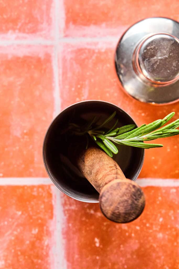 Wash rosemary in a shaker.