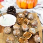Pumpkin Spice Almond Flour Donut Holes on a cutting board with a side of glaze.