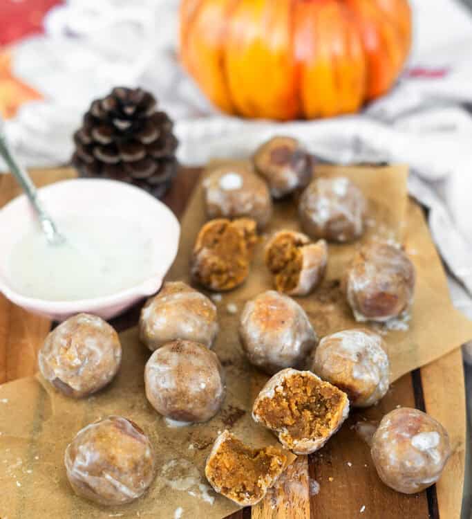 Pumpkin Spice Almond Flour Donut Holes on a cutting board with a side of glaze.