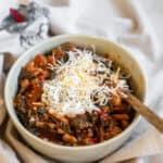 Spicy Sausage & Kale Chili in a bowl with a spoon.