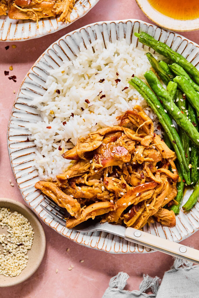 Crockpot Honey Garlic Chicken on a plate with rice and green beans.