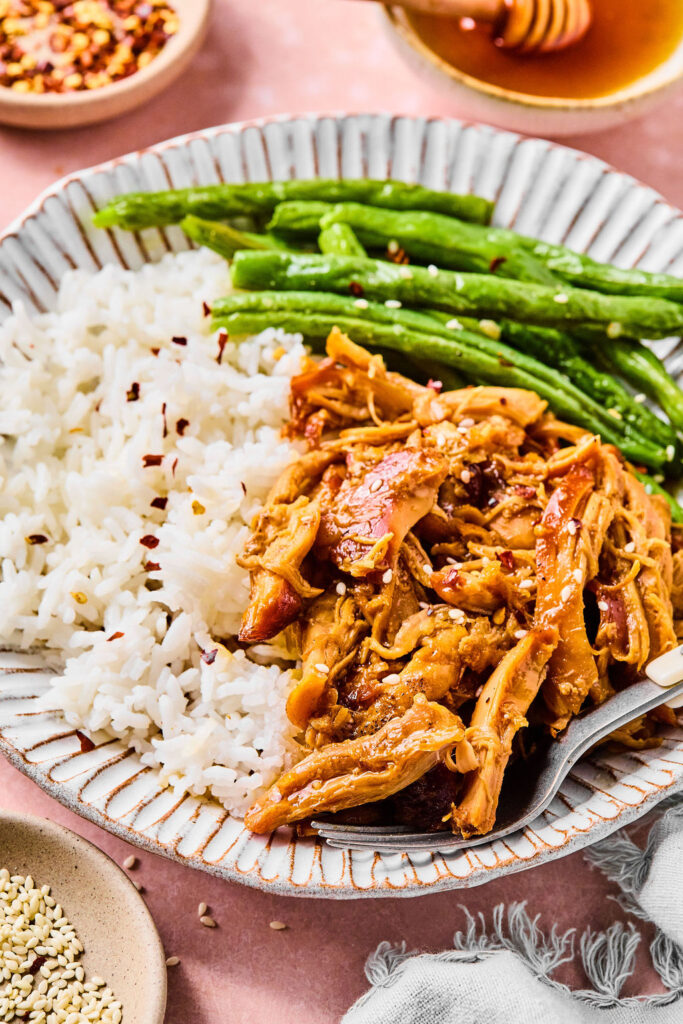 Crockpot Honey Garlic Chicken on a plate with rice and green beans.