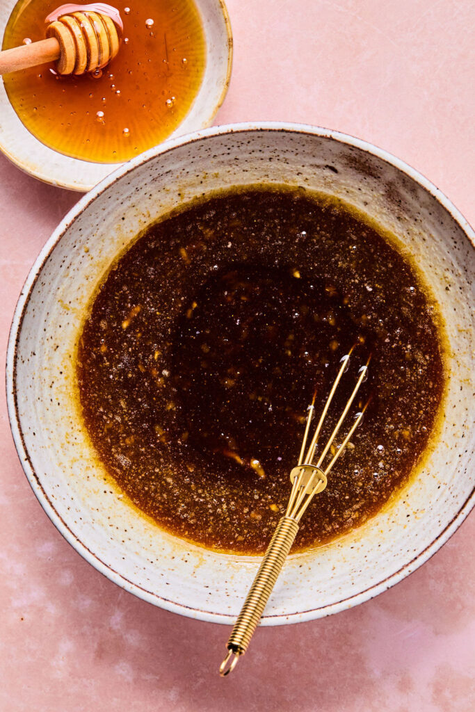 Sauce for Crockpot Honey Garlic Chicken in a small bowl with a whisk.