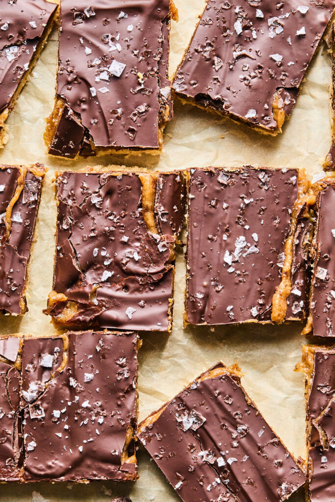 Salted Caramel Date Bars on parchment paper.