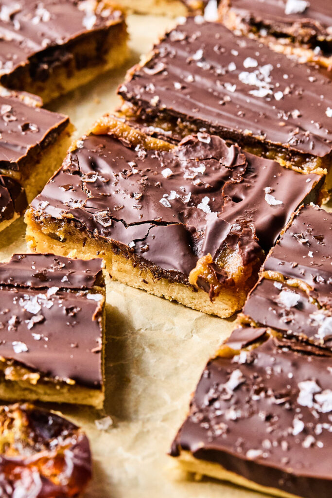 Salted Caramel Date Bars on parchment paper.